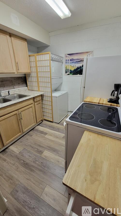 A kitchen with wooden cabinets and a white fridge.