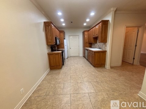 A kitchen with wooden cabinets and a tiled floor.