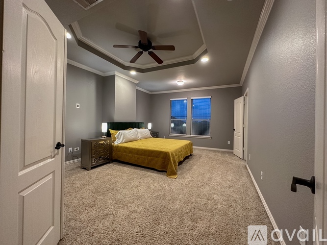 A bedroom with a bed, nightstand, and ceiling fan.