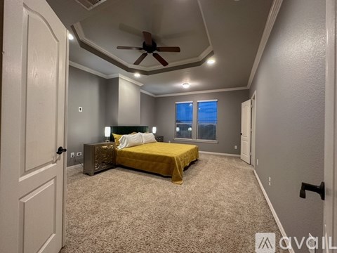 A bedroom with a bed, nightstand, and ceiling fan.