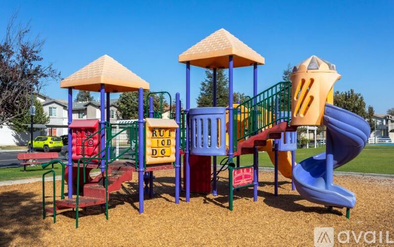 A playground with a blue slide and a red and yellow structure.
