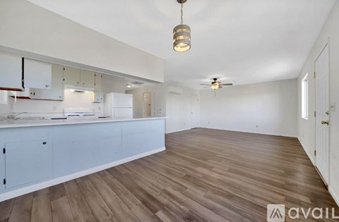 A kitchen with white cabinets and a wooden floor.