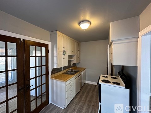 A small kitchen with a white fridge and wooden countertops.
