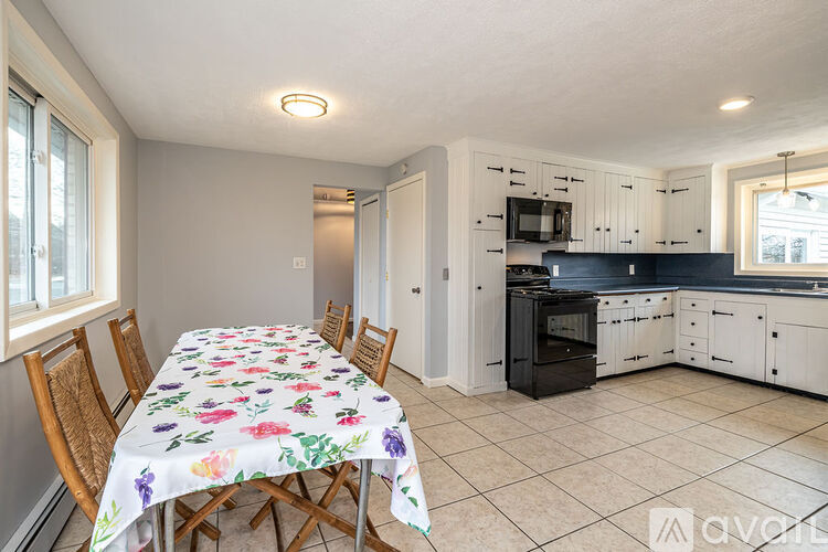 A kitchen with a table set for four with a floral tablecloth.