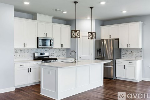A kitchen with white cabinets and a central island.