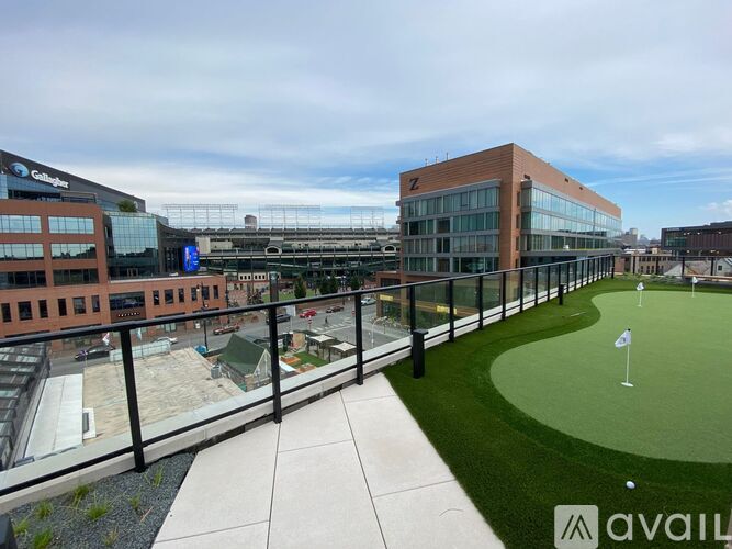 A golf putting green is located on the roof of a building.
