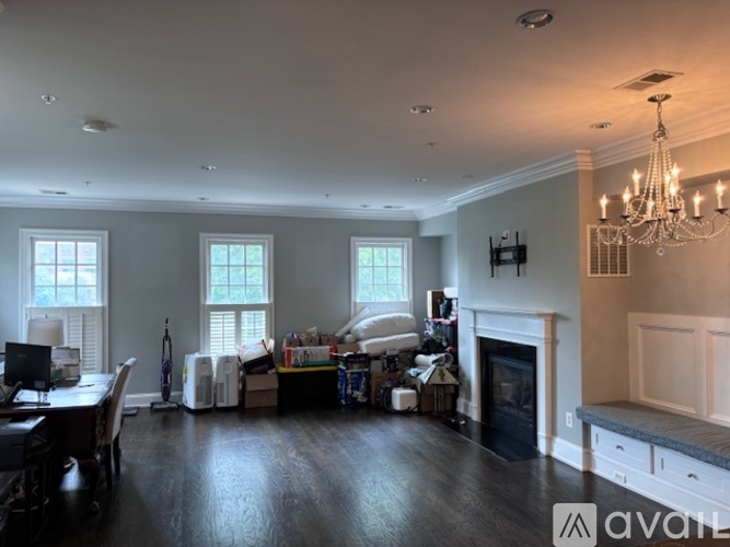 A large, empty living room with a fireplace and a dining table.