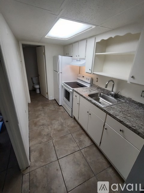 A kitchen with white cabinets and a granite countertop.