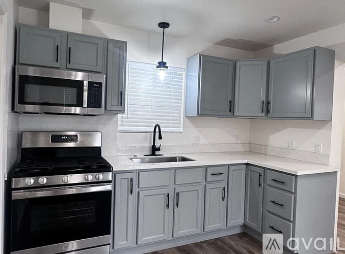 A kitchen with a stove, microwave, and cabinets.
