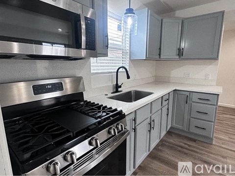 A modern kitchen with a stove top oven and a sink.