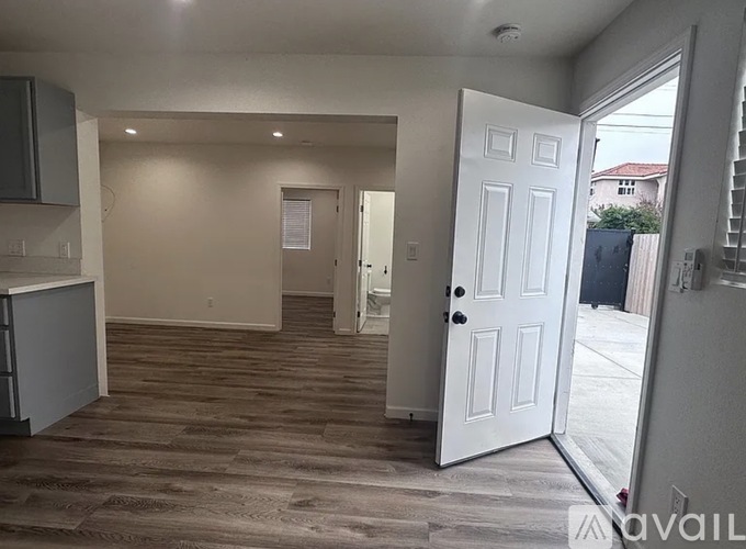 A room with a white door and a wooden floor.