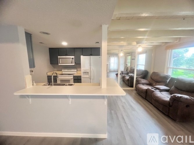 A kitchen with a white countertop and a microwave above it.