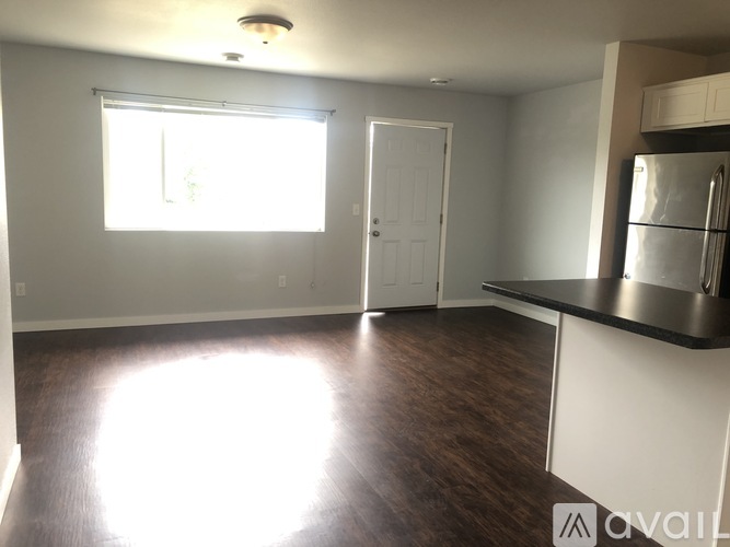 A kitchen with a refrigerator, sink, and cabinets.
