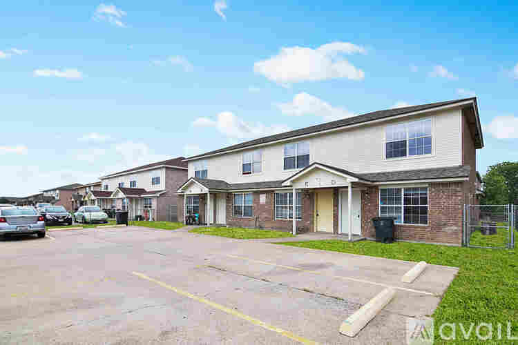 A row of houses with a parking lot in front.