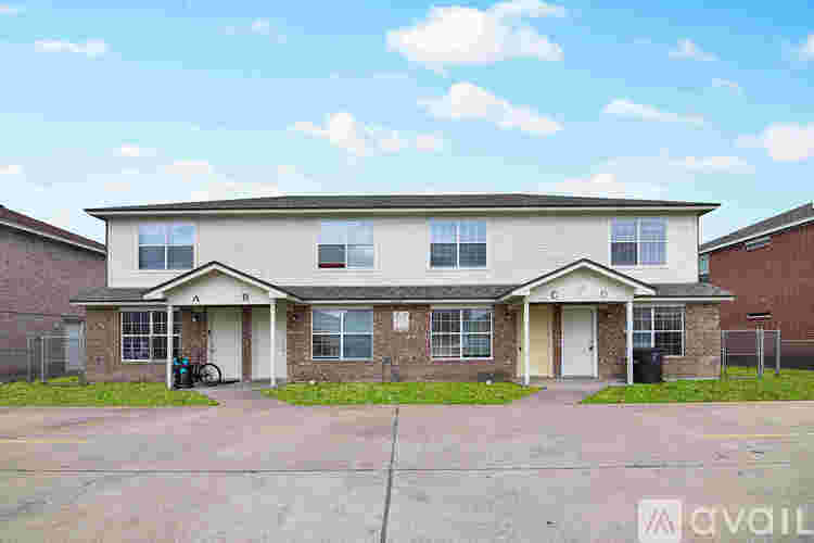 A two-story house with a front porch and a driveway.