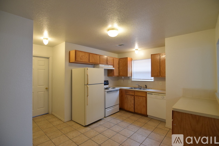 A kitchen with white appliances and wooden cabinets.