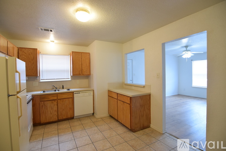 A kitchen with wooden cabinets and a white refrigerator.