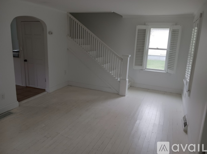A spacious room with a staircase leading to the second floor.