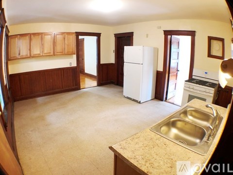 A kitchen with a white refrigerator and a sink.