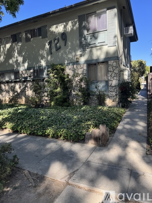 A house numbered 129 with a green bush in front.