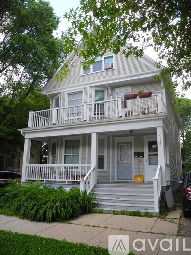 A two-story house with a balcony and a blue door.