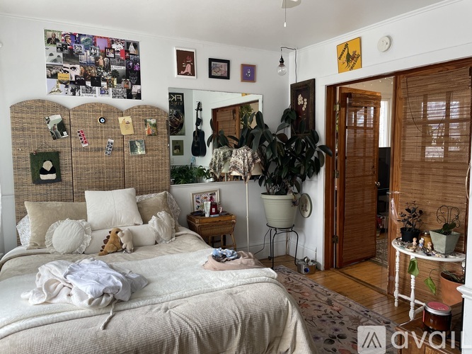 A bedroom with a large bed and a guitar hanging on the wall.