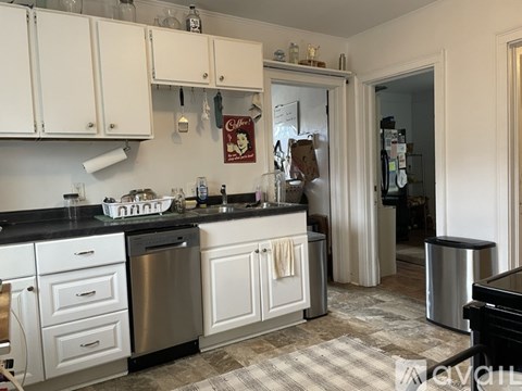 A kitchen with white cabinets and a black countertop.