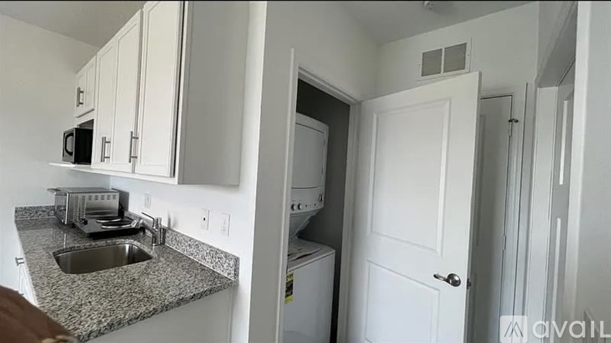 A kitchen with white cabinets and a granite countertop.