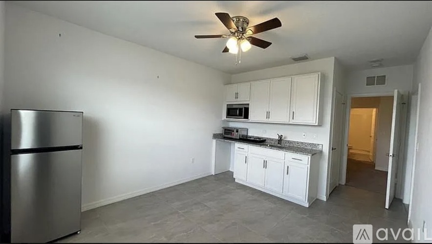 A kitchen with white cabinets and a stainless steel refrigerator.
