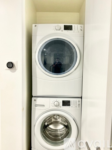 Two white washing machines in a small space.