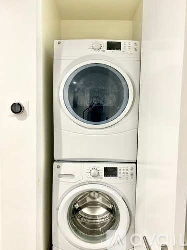 Two white washing machines in a small space.