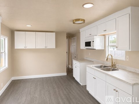 A kitchen with white cabinets and a sink.