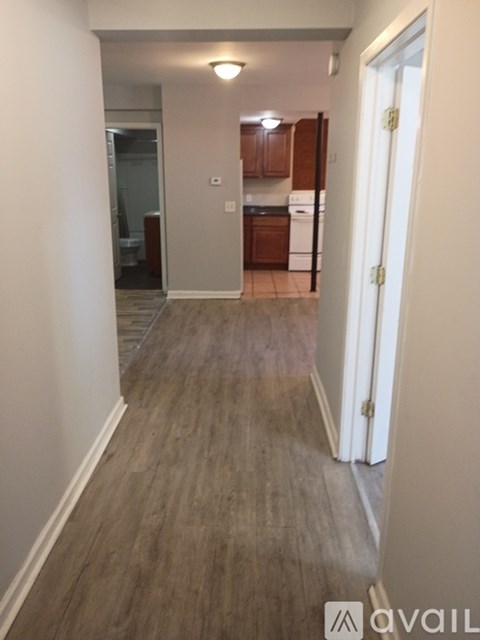 A hallway with wood flooring and white walls.