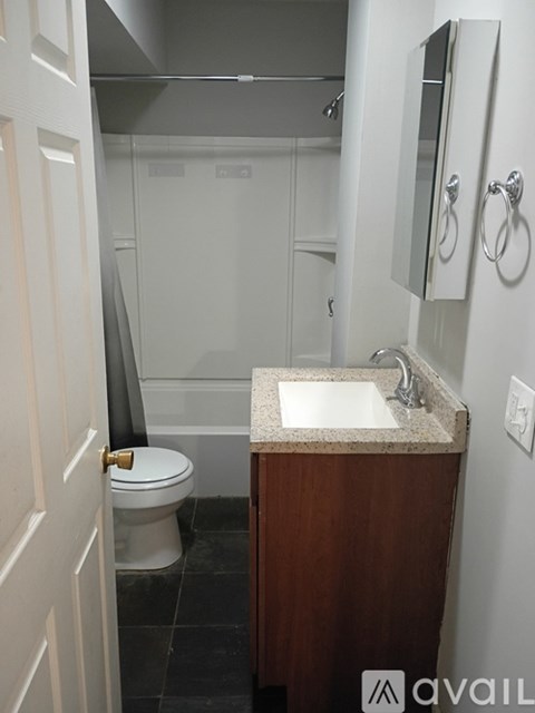A bathroom with a toilet, sink, and mirror.