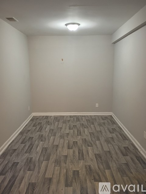 A room with wooden flooring and a light on the ceiling.