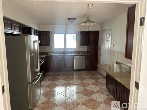 A kitchen with a checkered floor and a refrigerator.
