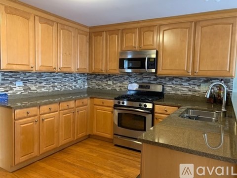 A kitchen with wooden cabinets and a granite countertop.