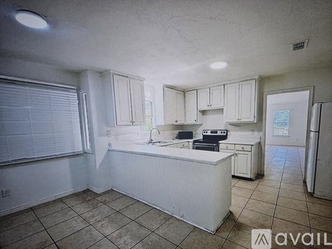 A kitchen with white cabinets and a white island.