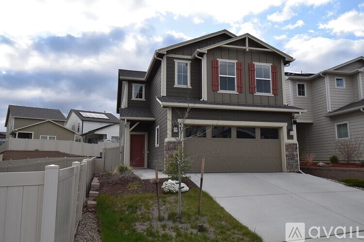 A house with a grey facade and red shutters is for sale.