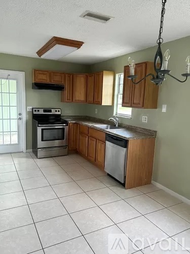 A kitchen with wooden cabinets and a stainless steel dishwasher.
