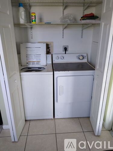 A small white laundry room with a washer and dryer.
