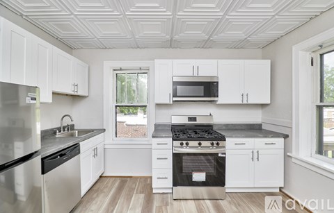 A kitchen with white cabinets and stainless steel appliances.