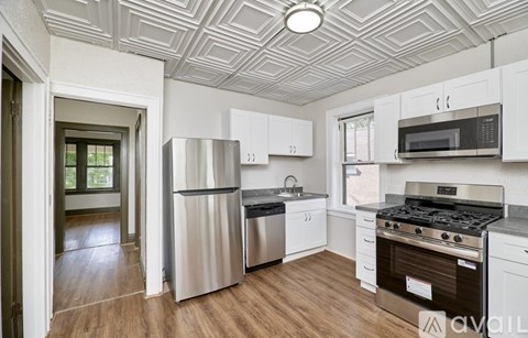 A kitchen with white cabinets and a stainless steel refrigerator.