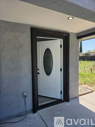 A white door with a glass window is set in a grey wall.