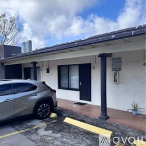 A silver car is parked in a yellow box.