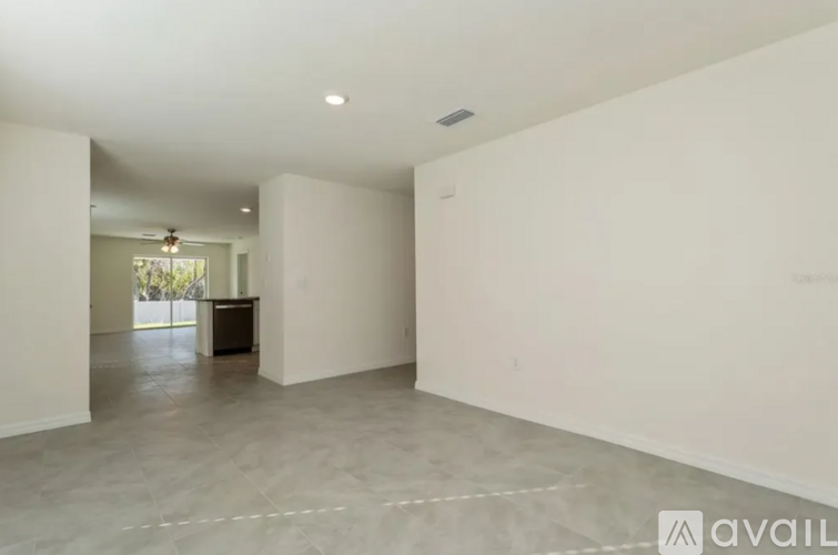 A spacious room with a ceiling fan and a cabinet in the middle.