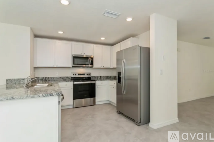 A kitchen with white cabinets and stainless steel appliances.