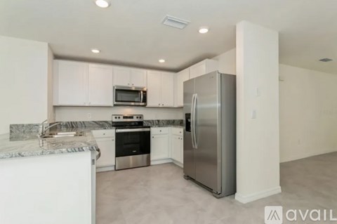 A kitchen with white cabinets and stainless steel appliances.