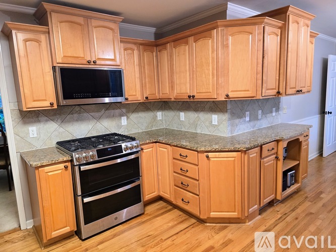 A kitchen with wooden cabinets and a granite countertop.