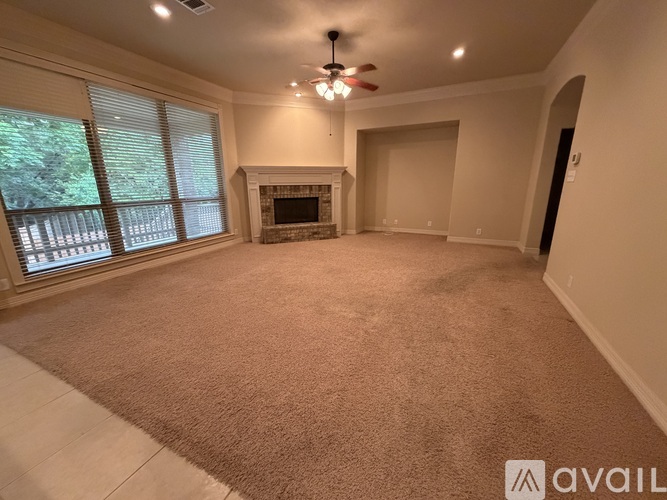 A living room with a fireplace and a ceiling fan.